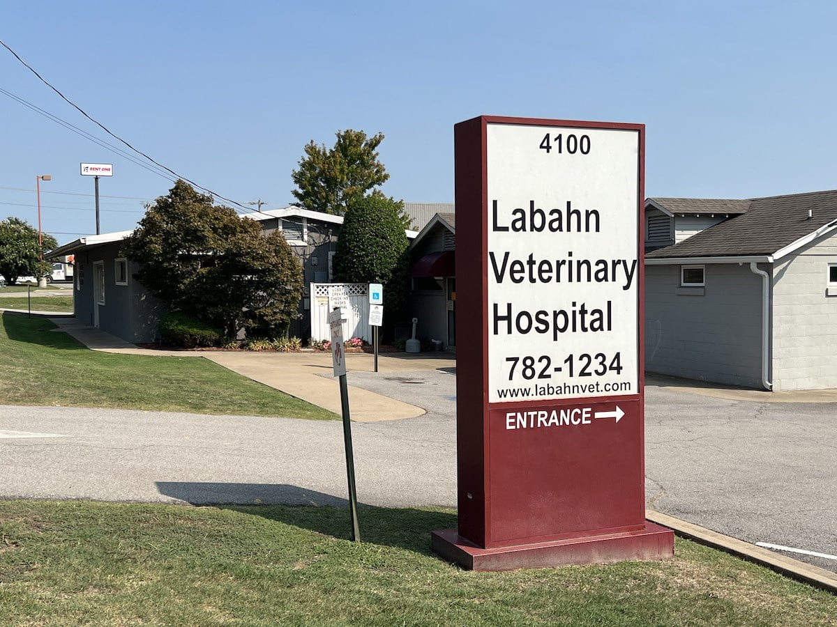 A photo of a sign with the Labahn Veterinary Hospital building in the background